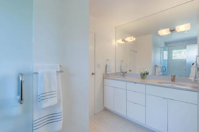 a bathroom with a double vanity sink and a mirror