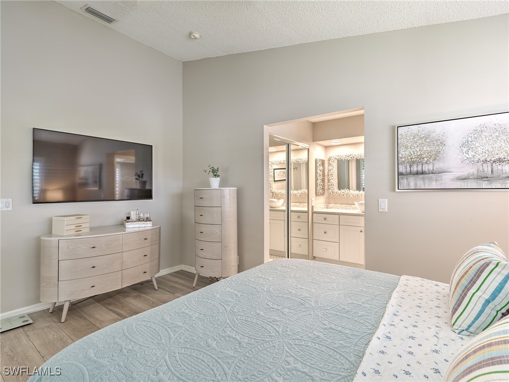 14981 Rivers Edge Court, Unit 228 Fort Myers, FL 33908 - Photo 16 of 40 a bedroom with a bed and a flat screen tv
