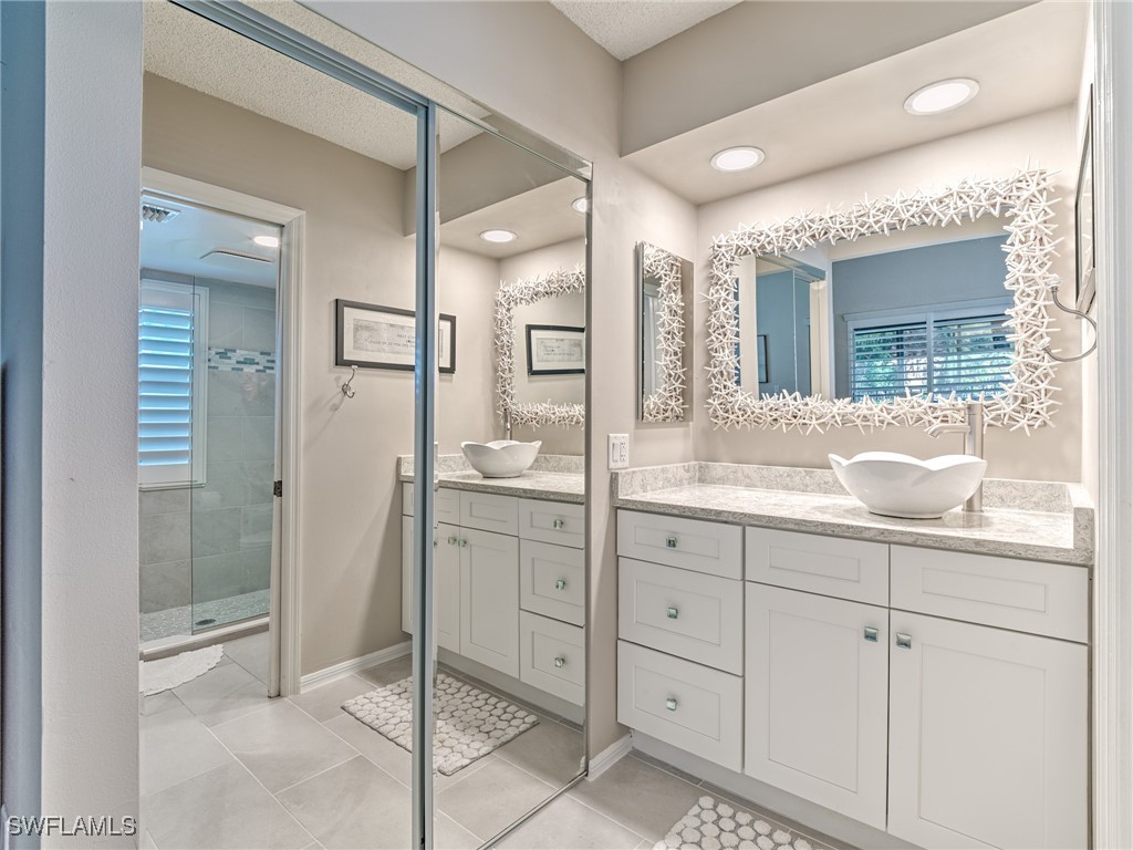 14981 Rivers Edge Court, Unit 228 Fort Myers, FL 33908 - Photo 21 of 40 a bathroom with a shower sink and mirror