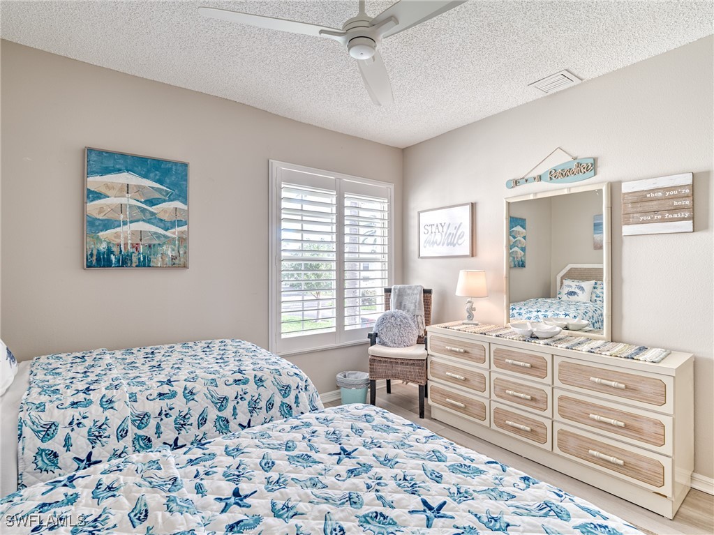 14981 Rivers Edge Court, Unit 228 Fort Myers, FL 33908 - Photo 26 of 40 a bedroom with a bed and wooden cabinets