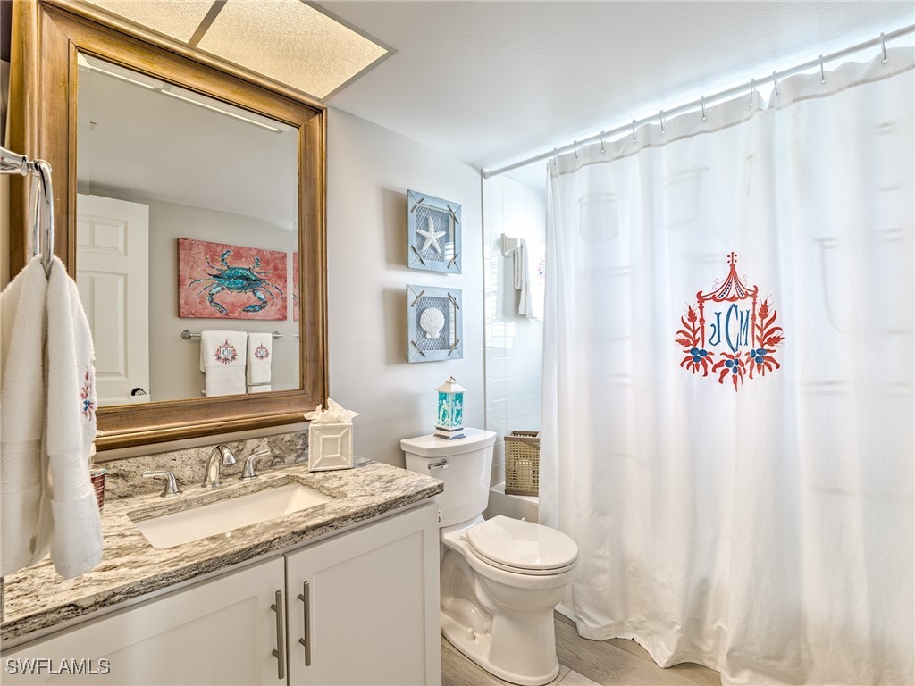 14981 Rivers Edge Court, Unit 228 Fort Myers, FL 33908 - Photo 27 of 40 a bathroom with a sink a toilet and a shower curtain