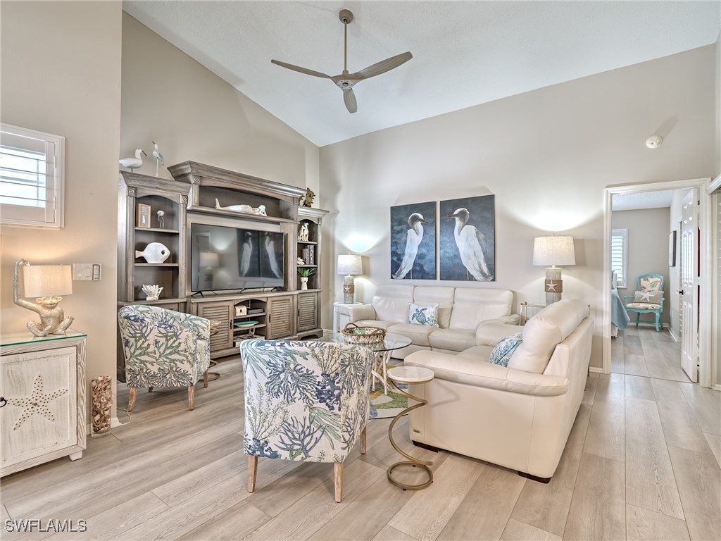 14981 Rivers Edge Court, Unit 228 Fort Myers, FL 33908 - Photo 5 of 40 a living room with furniture a flat screen tv and a table