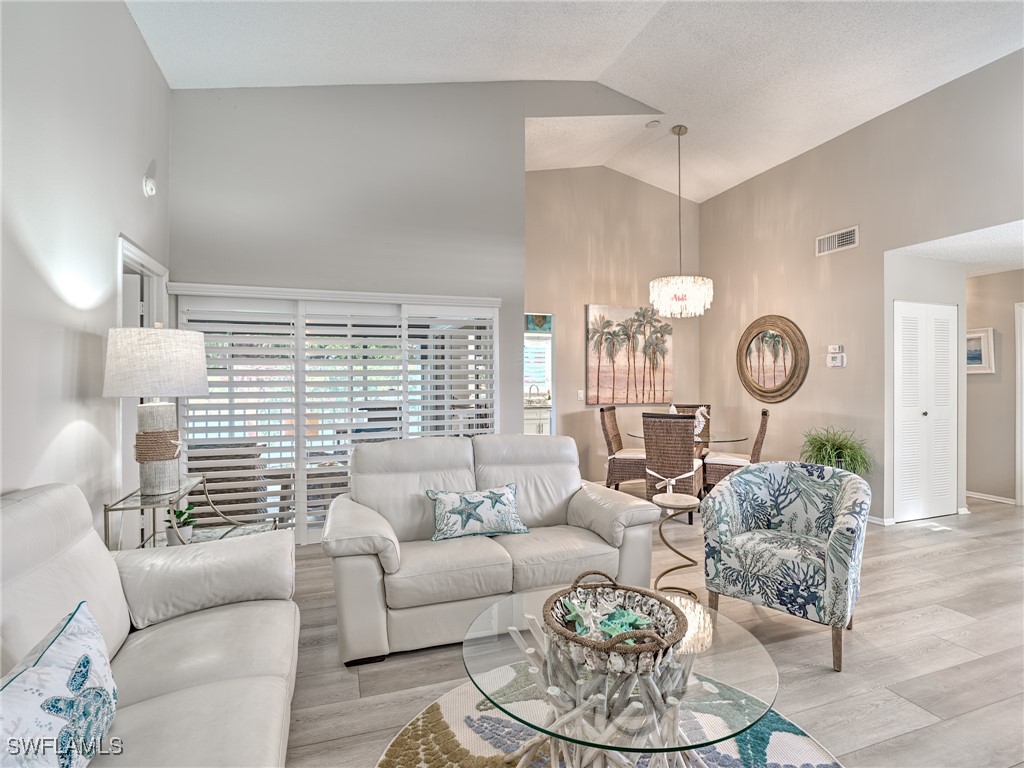 14981 Rivers Edge Court, Unit 228 Fort Myers, FL 33908 - Photo 8 of 40 a living room with furniture a clock and a large window