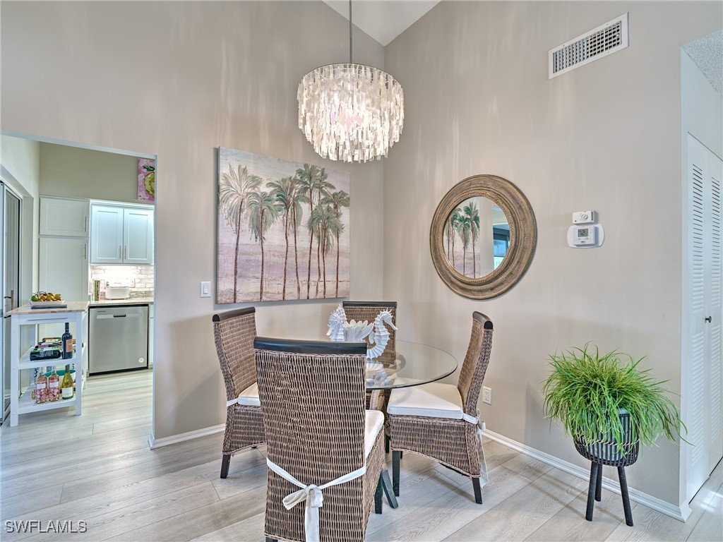 14981 Rivers Edge Court, Unit 228 Fort Myers, FL 33908 - Photo 9 of 40 a dining room with furniture and a chandelier