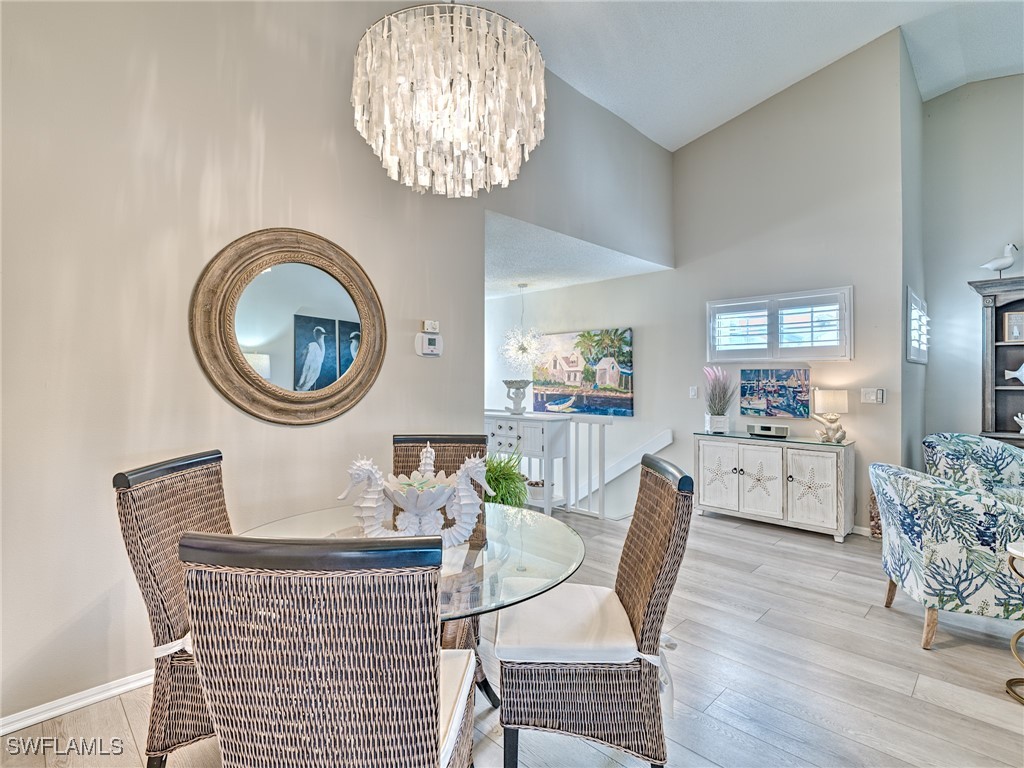 14981 Rivers Edge Court, Unit 228 Fort Myers, FL 33908 - Photo 10 of 40 a dining room with furniture a chandelier and wooden floor