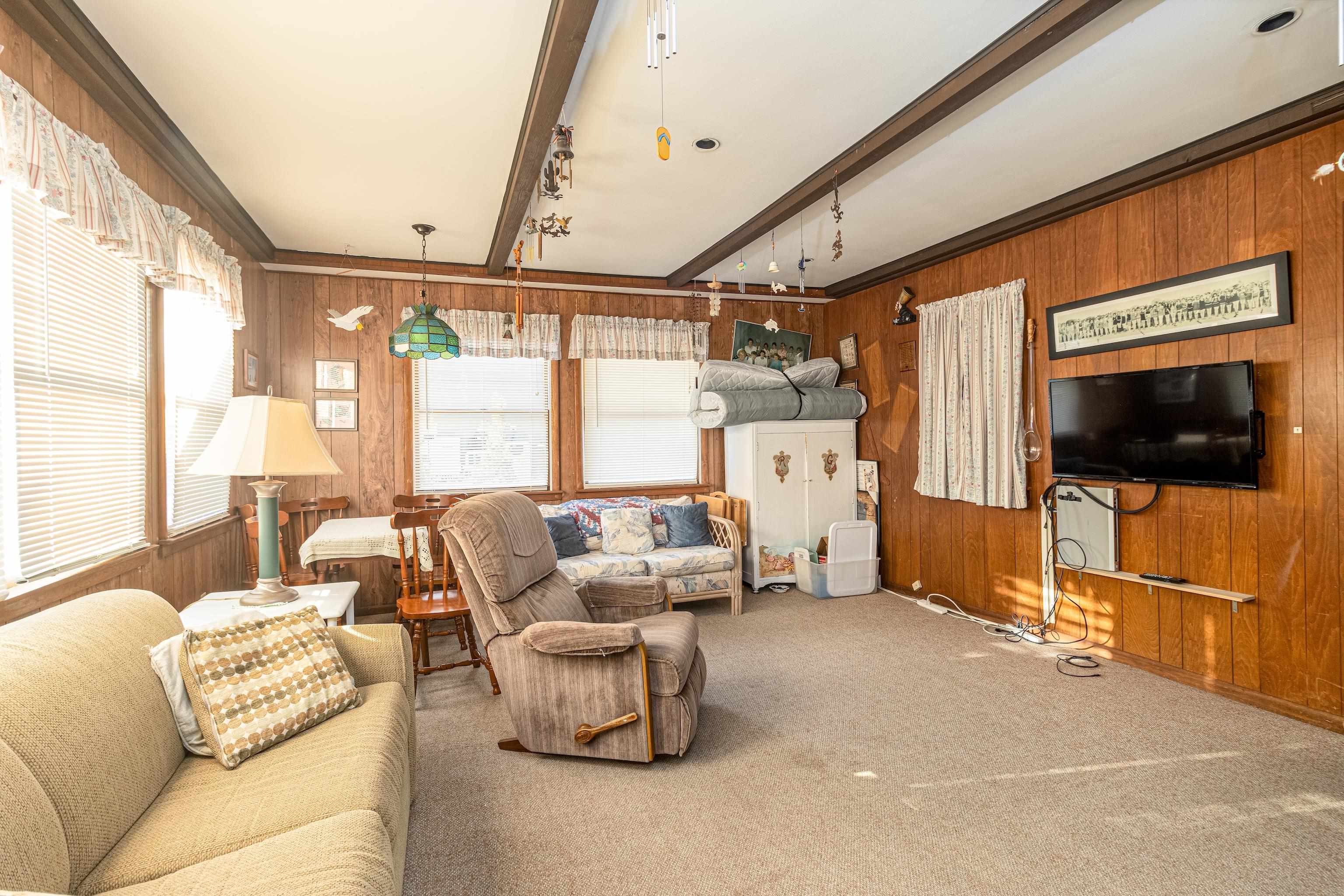1745 1st Avalon, NJ 08202 - Photo 15 of 17 a living room with furniture a flat screen tv and a floor to ceiling window