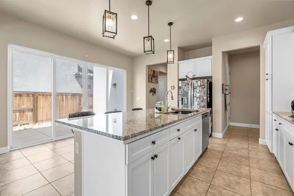 a kitchen with stainless steel appliances granite countertop a stove top oven a sink a counter space and cabinets