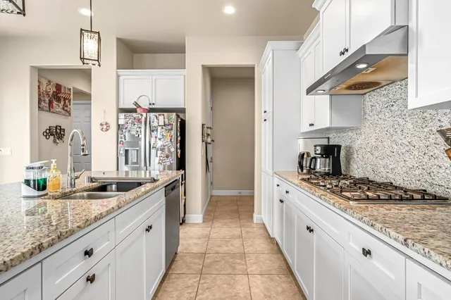 a large kitchen with stainless steel appliances granite countertop a lot of counter space and a sink