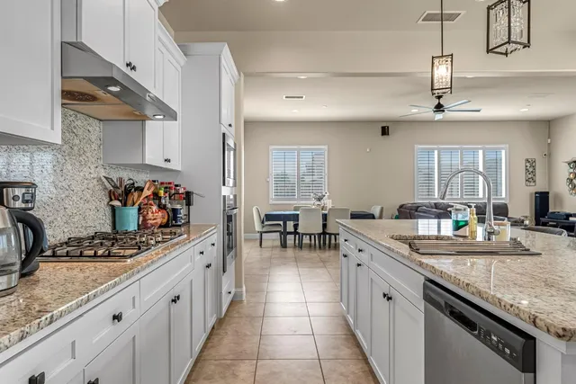 a kitchen with stainless steel appliances granite countertop a sink stove and cabinets