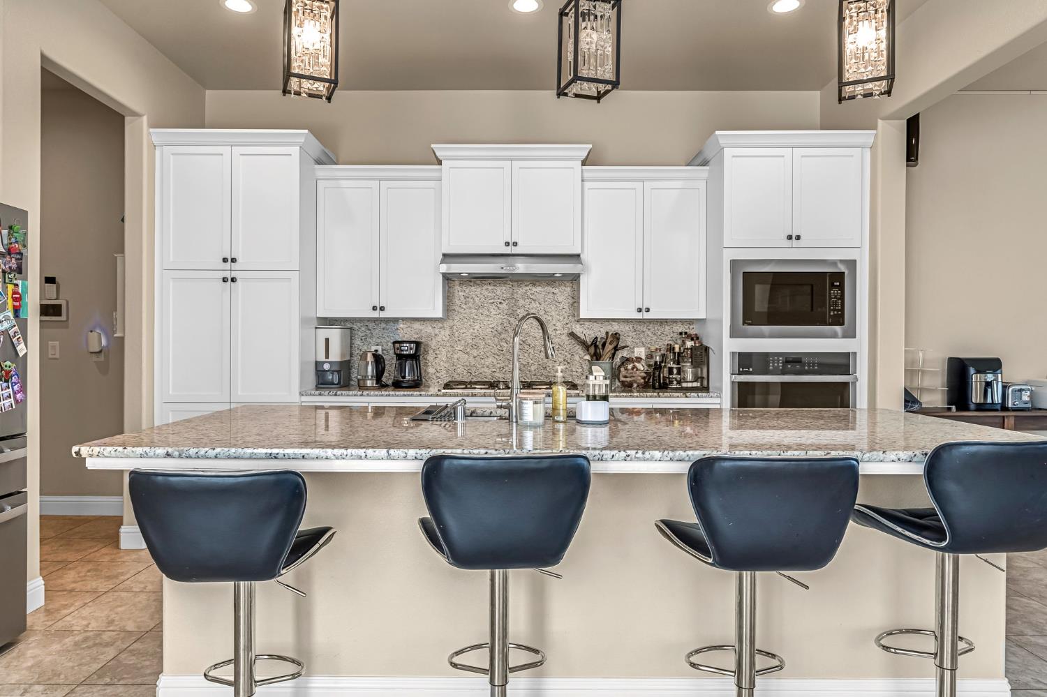 2468 Montana Avenue Clovis, CA 93619 - Photo 19 of 33 a kitchen with stainless steel appliances granite countertop a stove a sink a refrigerator and a dining table with wooden floor