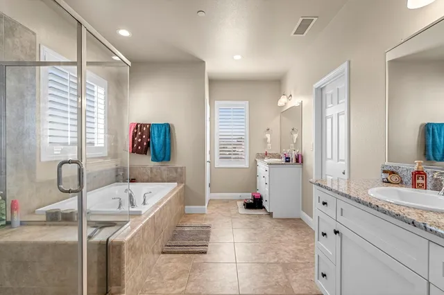a bathroom with a tub sink and mirror