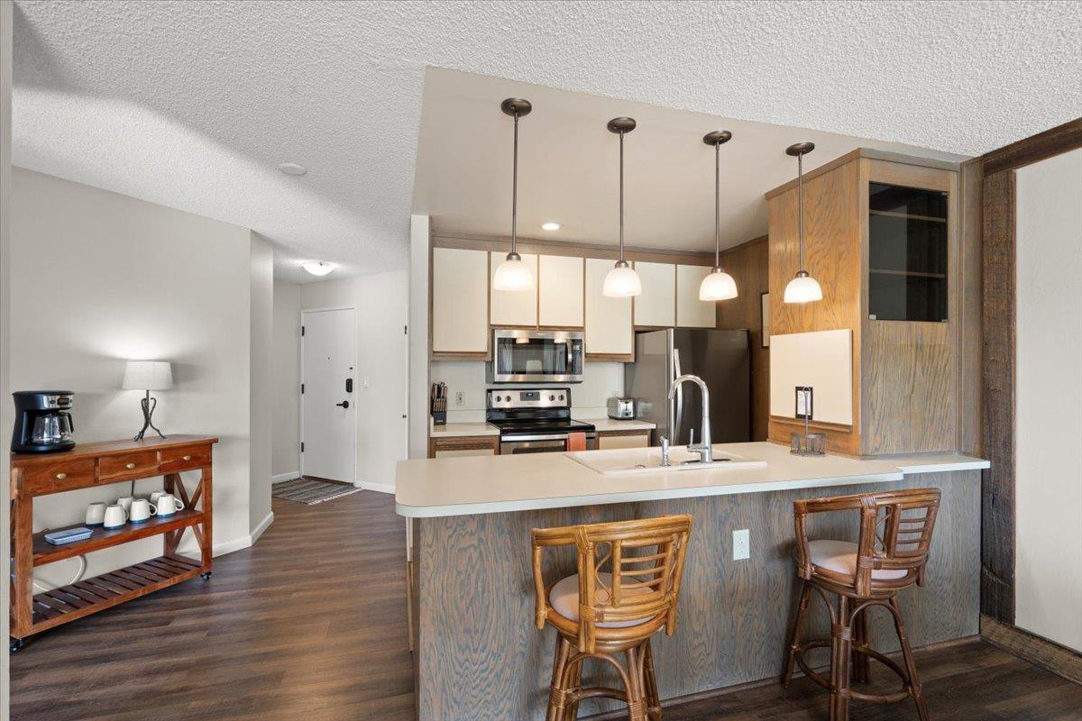 101 Shell Road, Unit 211 Watsonville, CA 95076 - Photo 12 of 29 a kitchen with stainless steel appliances kitchen island granite countertop a stove a sink and a wooden cabinets