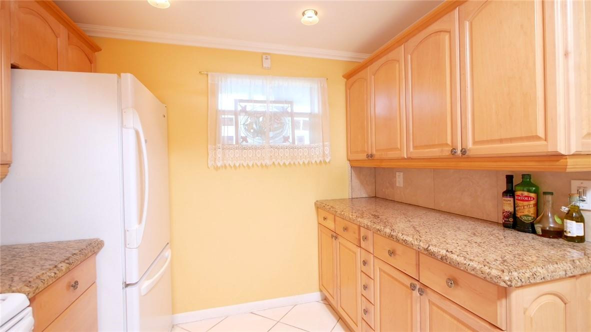 3930 Inverrary Boulevard, Unit 105D Lauderhill, FL 33319 - Photo 12 of 46 a kitchen with stainless steel appliances granite countertop a sink and cabinets