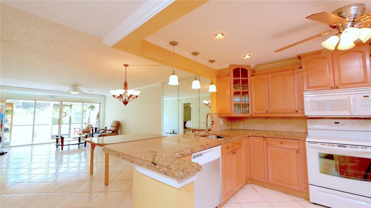 3930 Inverrary Boulevard, Unit 105D Lauderhill, FL 33319 - Photo 15 of 46 a kitchen with stainless steel appliances granite countertop a sink and cabinets