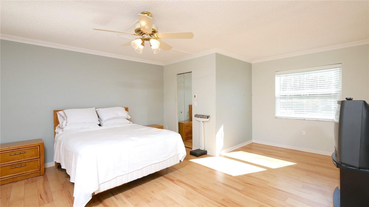 3930 Inverrary Boulevard, Unit 105D Lauderhill, FL 33319 - Photo 16 of 46 a bedroom with a large bed and a chandelier