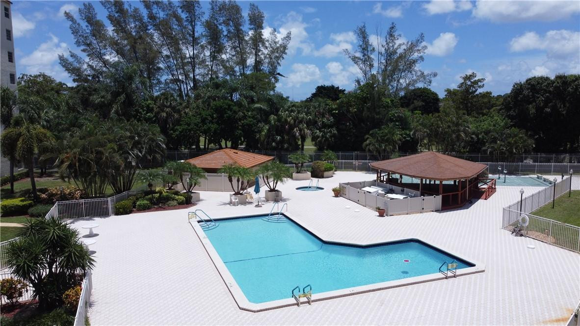 3930 Inverrary Boulevard, Unit 105D Lauderhill, FL 33319 - Photo 36 of 46 a view of a patio with table and chairs under an umbrella with a small yard