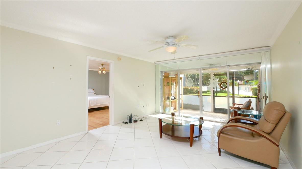 3930 Inverrary Boulevard, Unit 105D Lauderhill, FL 33319 - Photo 4 of 46 a living room with furniture and a large window