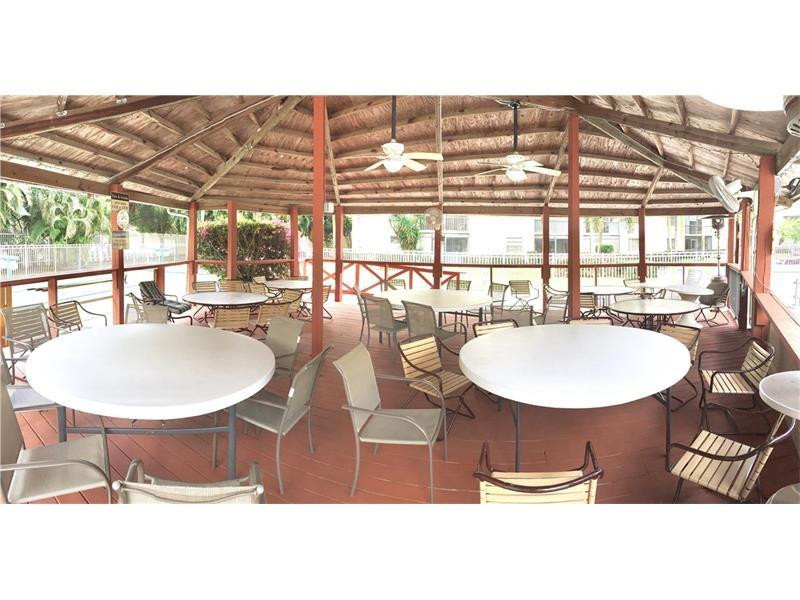 3930 Inverrary Boulevard, Unit 105D Lauderhill, FL 33319 - Photo 45 of 46 a dining room with furniture a window and a kitchen view