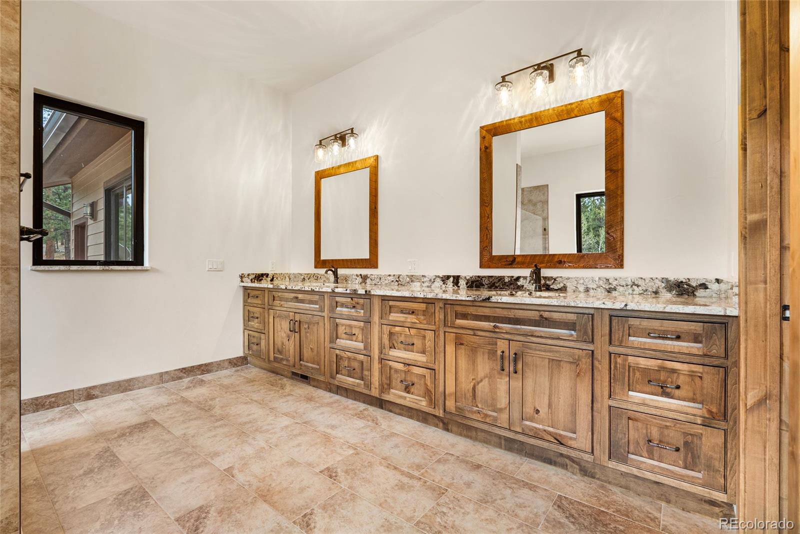 280 Double Tree Road Bailey, CO 80421 - Photo 32 of 43 a spacious bathroom with a double vanity sink and a mirror