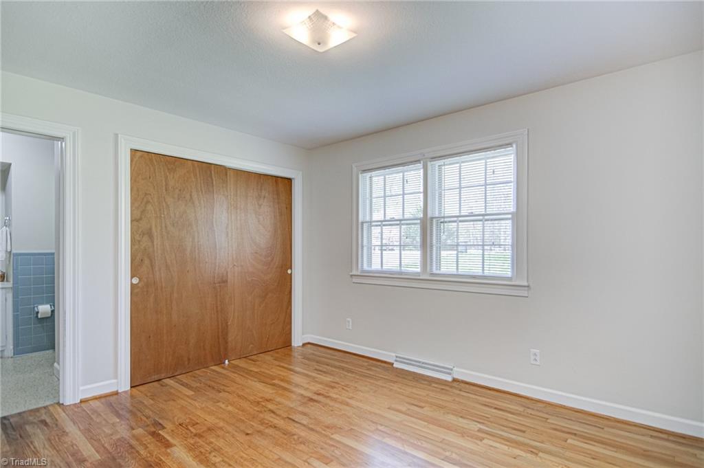 3602 Milhaven Road Winston-Salem, NC 27106 - Photo 17 of 36 Original hardwood floors in primary bedroom with ensuite shower/bathroom