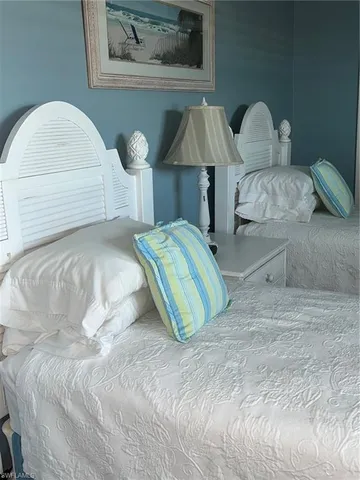 a bedroom with two beds and a painting on the wall