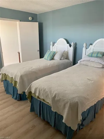 a bedroom with two beds and wooden floor