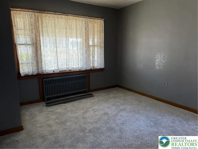 a room with water heater and wooden cabinets
