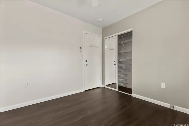 a view of an empty room with wooden floor