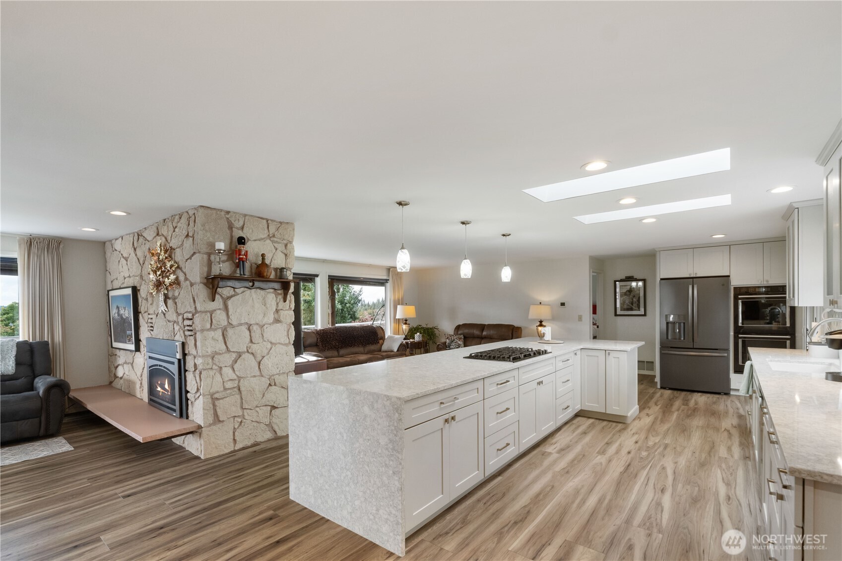 4911 Mildred Street Tacoma, WA 98407 - Photo 10 of 40 a large kitchen with stainless steel appliances kitchen island a large counter top and a refrigerator