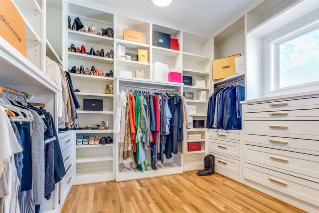 a view of walk in closet with clothes and shoes