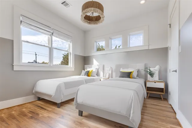 a bedroom with two beds and a large window