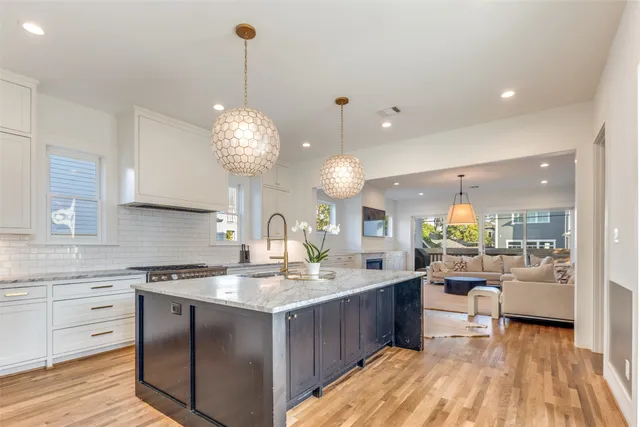 a large kitchen with kitchen island a large counter space a sink appliances and living room view
