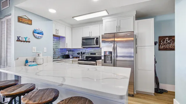 a kitchen with granite countertop a refrigerator and a stove top oven