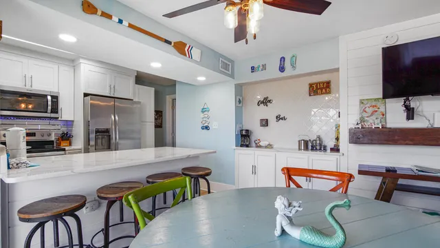 a living room with furniture kitchen view and a flat screen tv