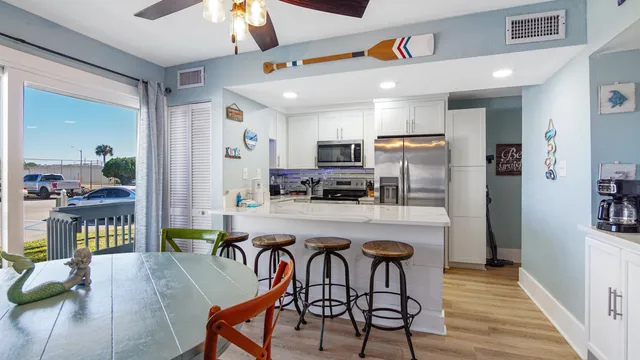 a kitchen with kitchen island a refrigerator and a dining table