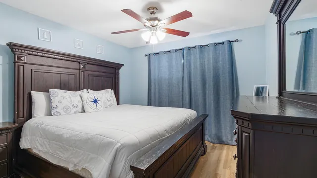 a bedroom with a large bed and a chandelier