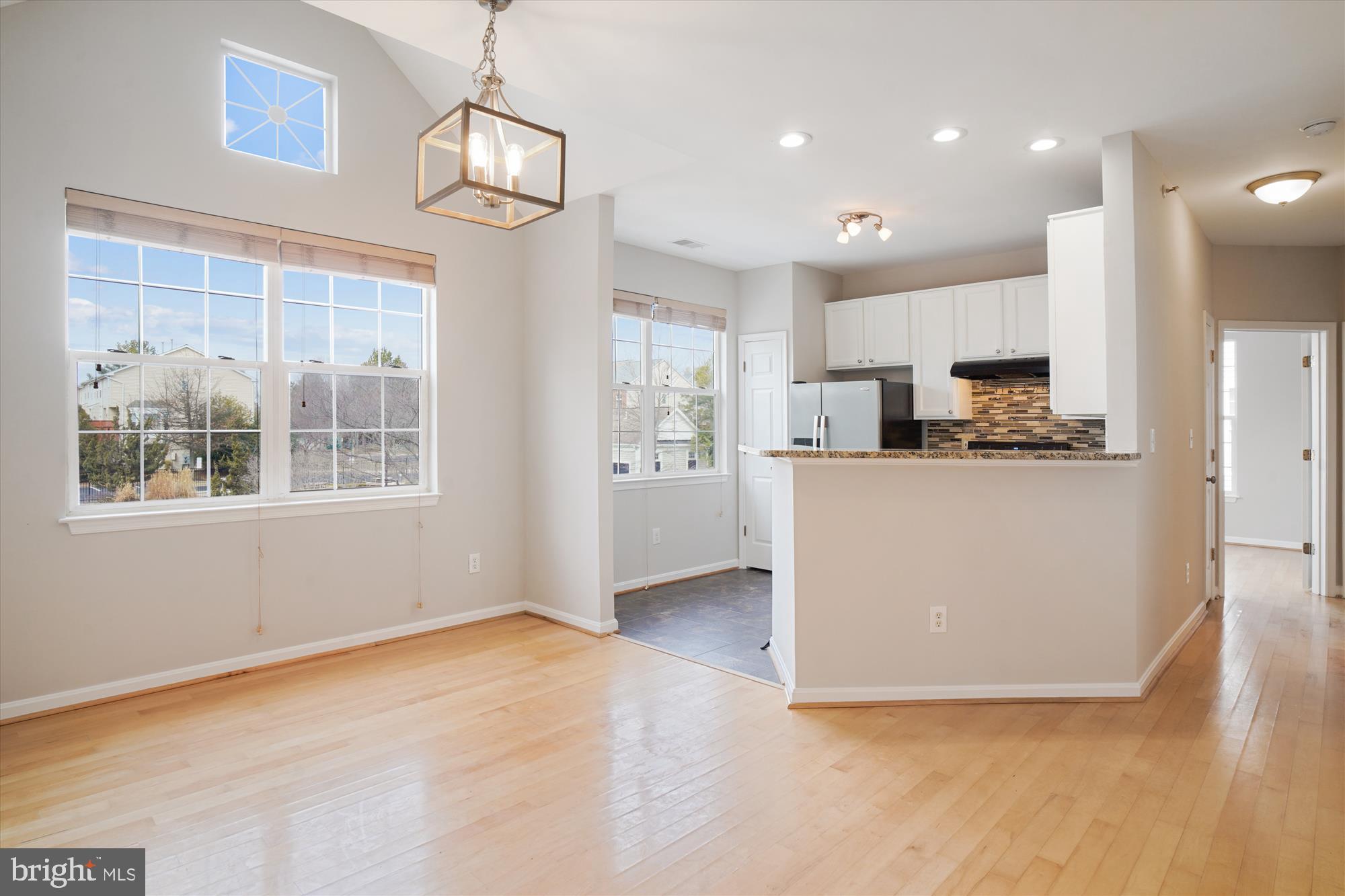 12712 Found Stone Road, Unit 4206 Germantown, MD 20876 - Photo 6 of 58 a view of kitchen with stainless steel appliances granite countertop a stove top oven a refrigerator a sink and a dining table with wooden floor