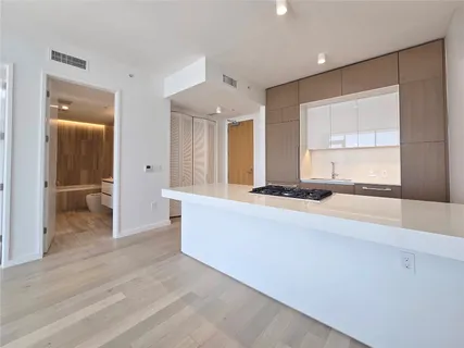 a living room with stainless steel appliances kitchen island granite countertop furniture and a large window