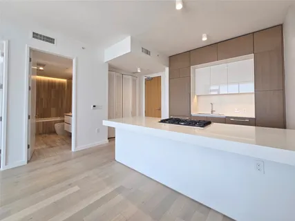 a living room with stainless steel appliances kitchen island granite countertop furniture and a large window