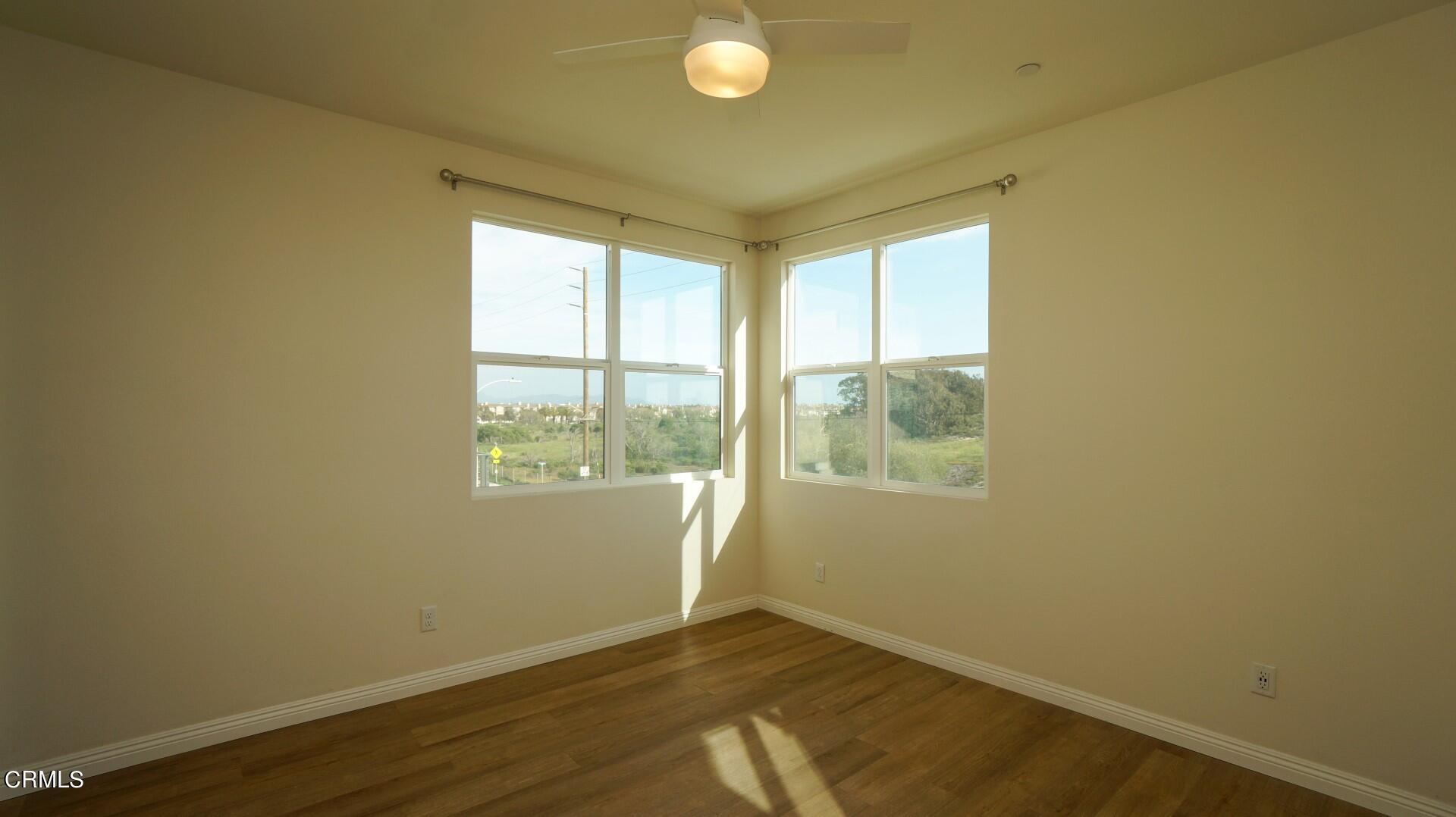 1063 Canal Street Oxnard, CA 93035 - Photo 12 of 32 an empty room with wooden floor and windows