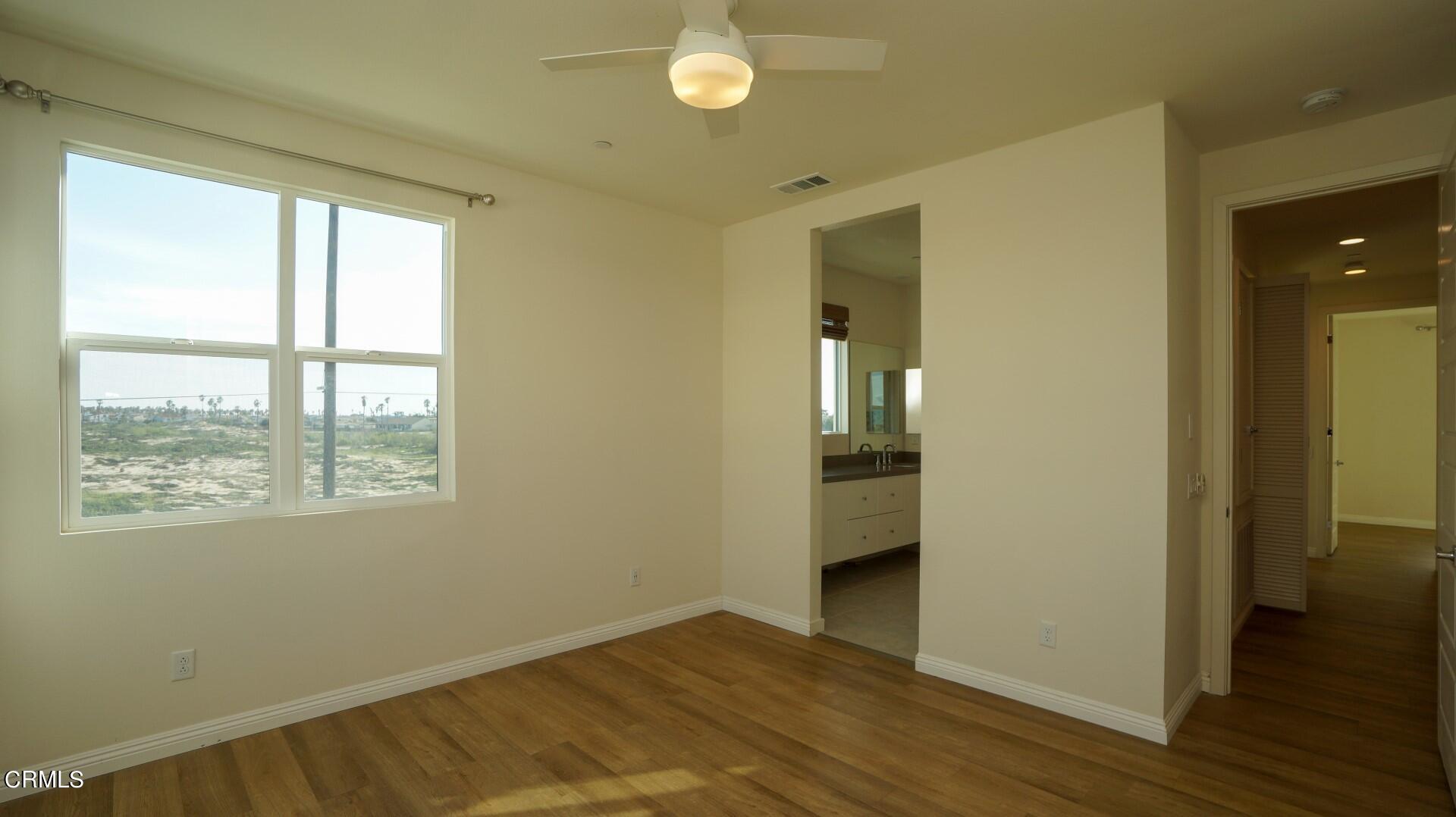 1063 Canal Street Oxnard, CA 93035 - Photo 13 of 32 a view of an empty room with wooden floor and a window