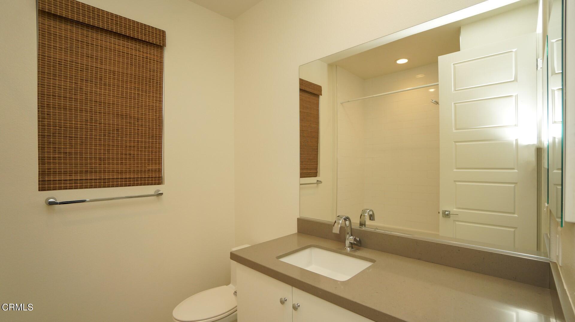 1063 Canal Street Oxnard, CA 93035 - Photo 21 of 32 a bathroom with a sink and mirror with toilet