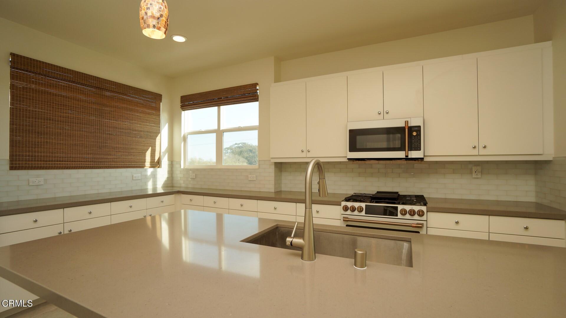 1063 Canal Street Oxnard, CA 93035 - Photo 5 of 32 a kitchen with stainless steel appliances a stove a sink and a microwave