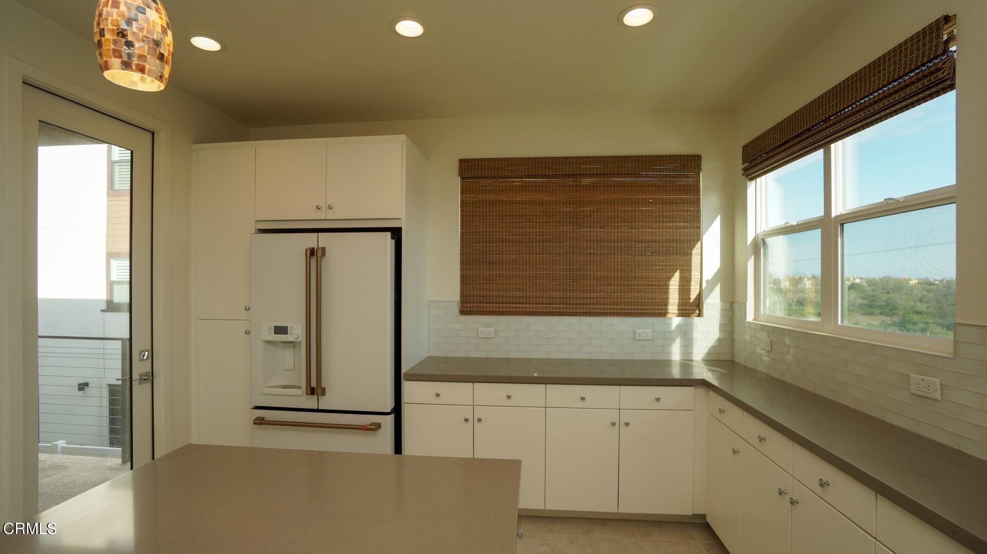 1063 Canal Street Oxnard, CA 93035 - Photo 6 of 32 a bathroom with a sink a large mirror and a bathtub next to a window