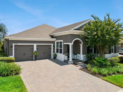 a front view of a house with a yard and potted plants