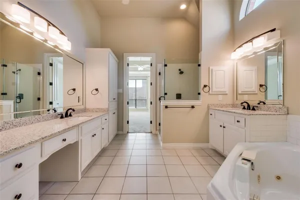 a large white bathroom with a double vanity sink toilet mirror and bathtub