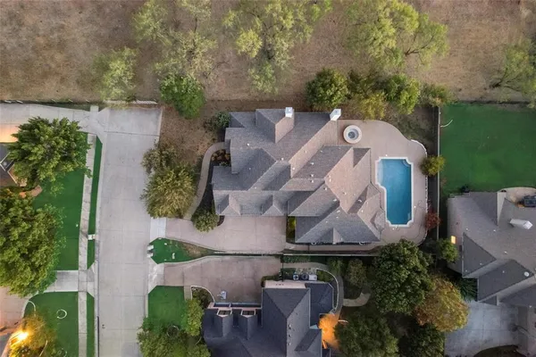 an aerial view of a house with a garden and a large tree