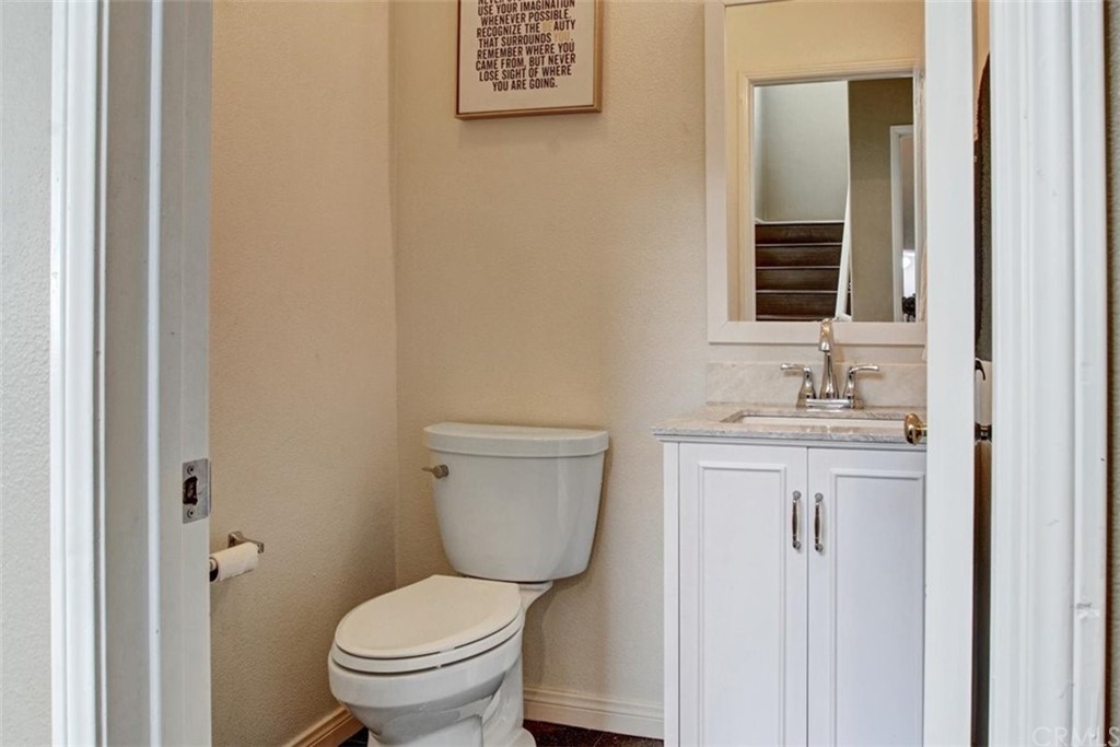 973 Thicket Drive Carson, CA 90746 - Photo 14 of 32 a bathroom with a granite countertop toilet a sink and a mirror