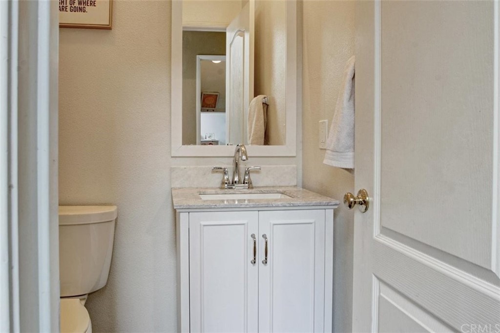 973 Thicket Drive Carson, CA 90746 - Photo 15 of 32 a bathroom with a granite countertop sink a toilet and a mirror