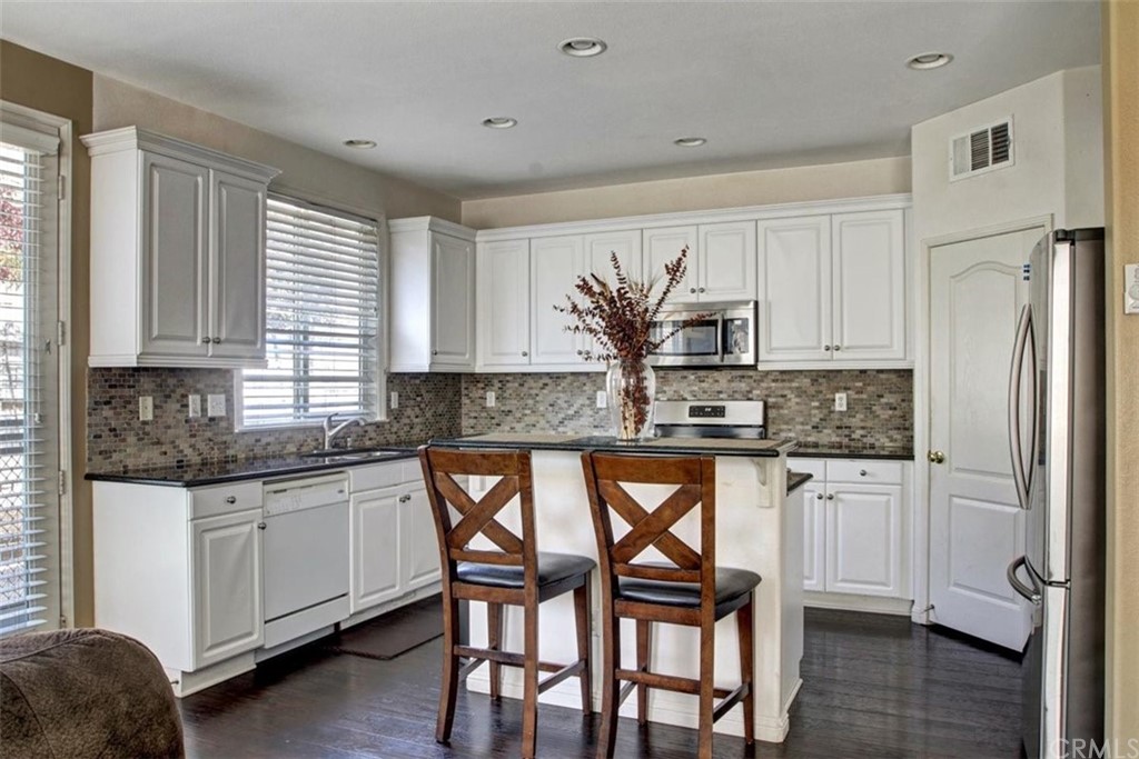 973 Thicket Drive Carson, CA 90746 - Photo 5 of 32 a kitchen with granite countertop white cabinets and stainless steel appliances